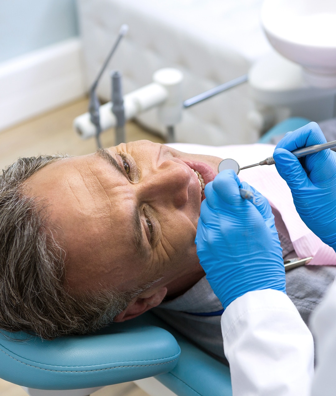 An elderly man in a dental chair having an exam done at esteem dental studio
