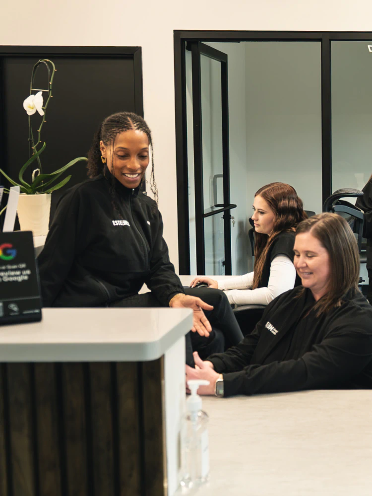 A young woman smiling up from a dental chair at esteem dental studio