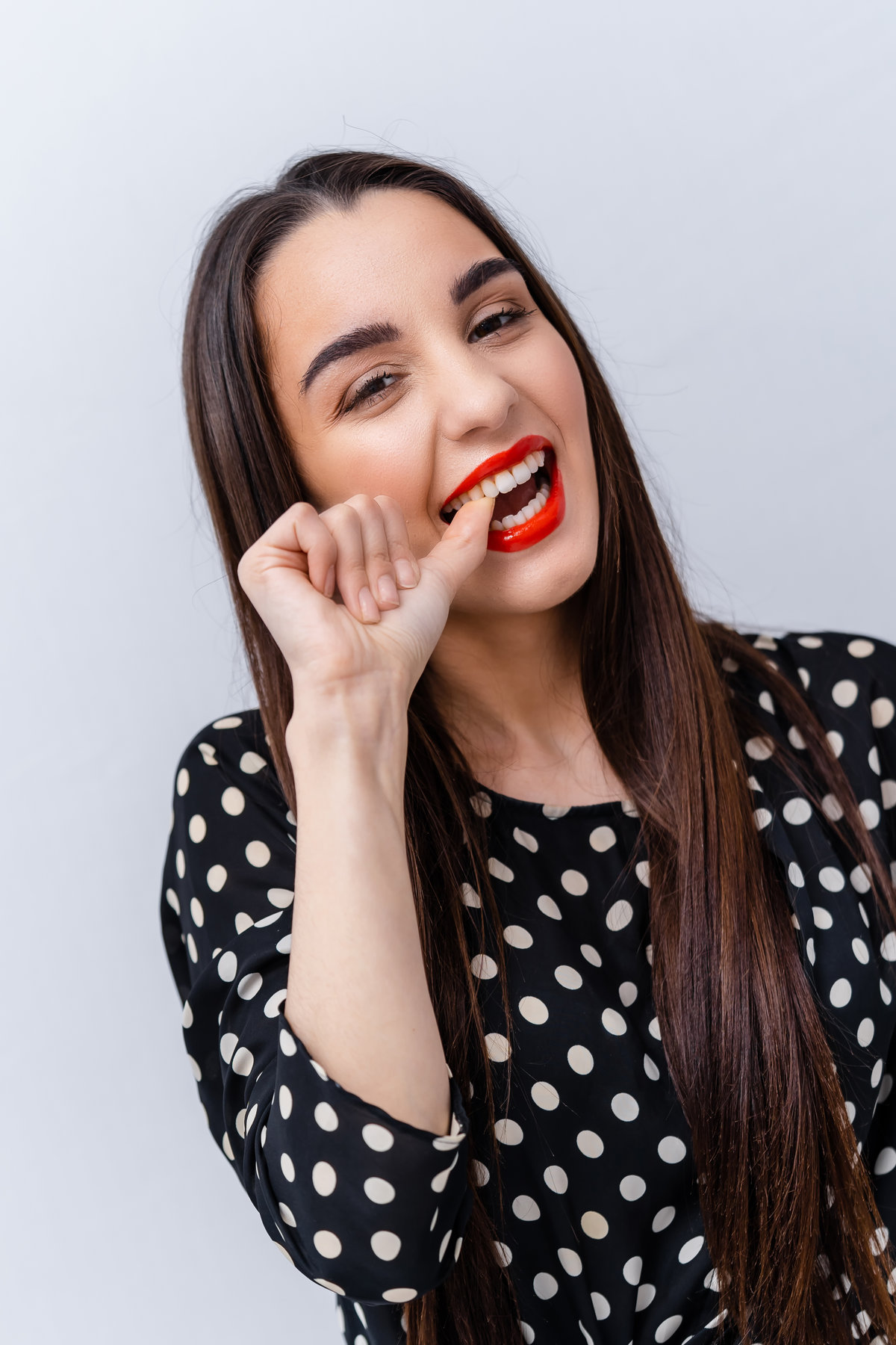 Perfectly white teeth of a girl. Woman shows happy emotion. Red lips contrust with ideal white teeth. White background.